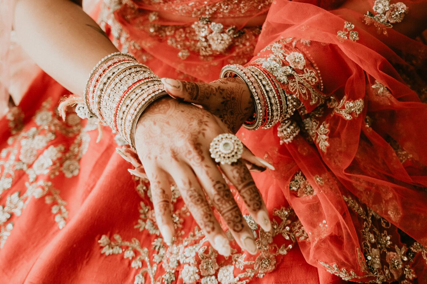 Detalle de las manos, joyas y vestuario de la novia