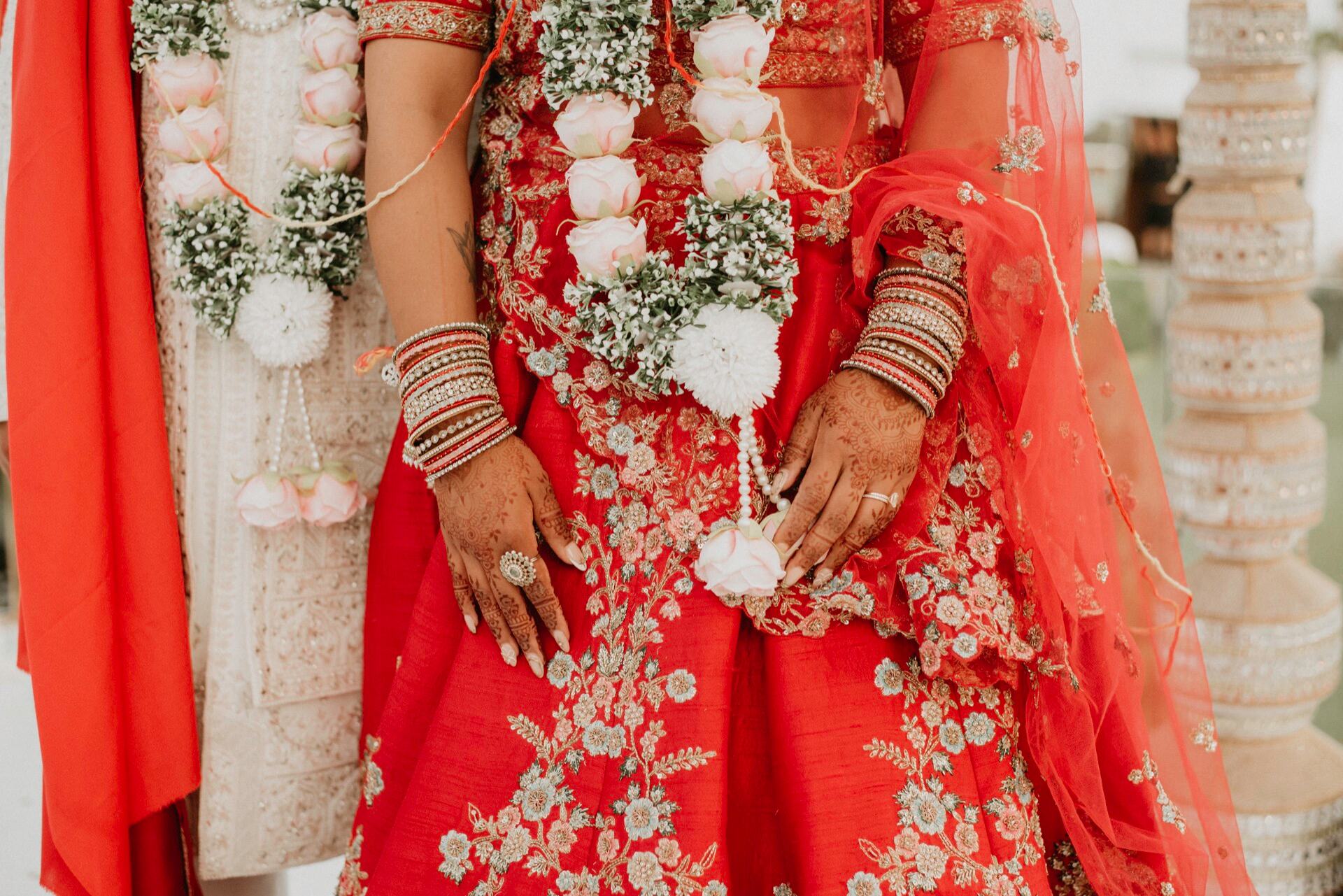 Detalle del vestuario, henna y guirnaldas florales de una boda hindú